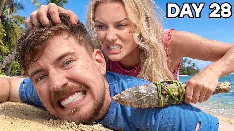The reference: a man lying on a tropical beach gripping a stone axe, a woman behind him, headline Day 28